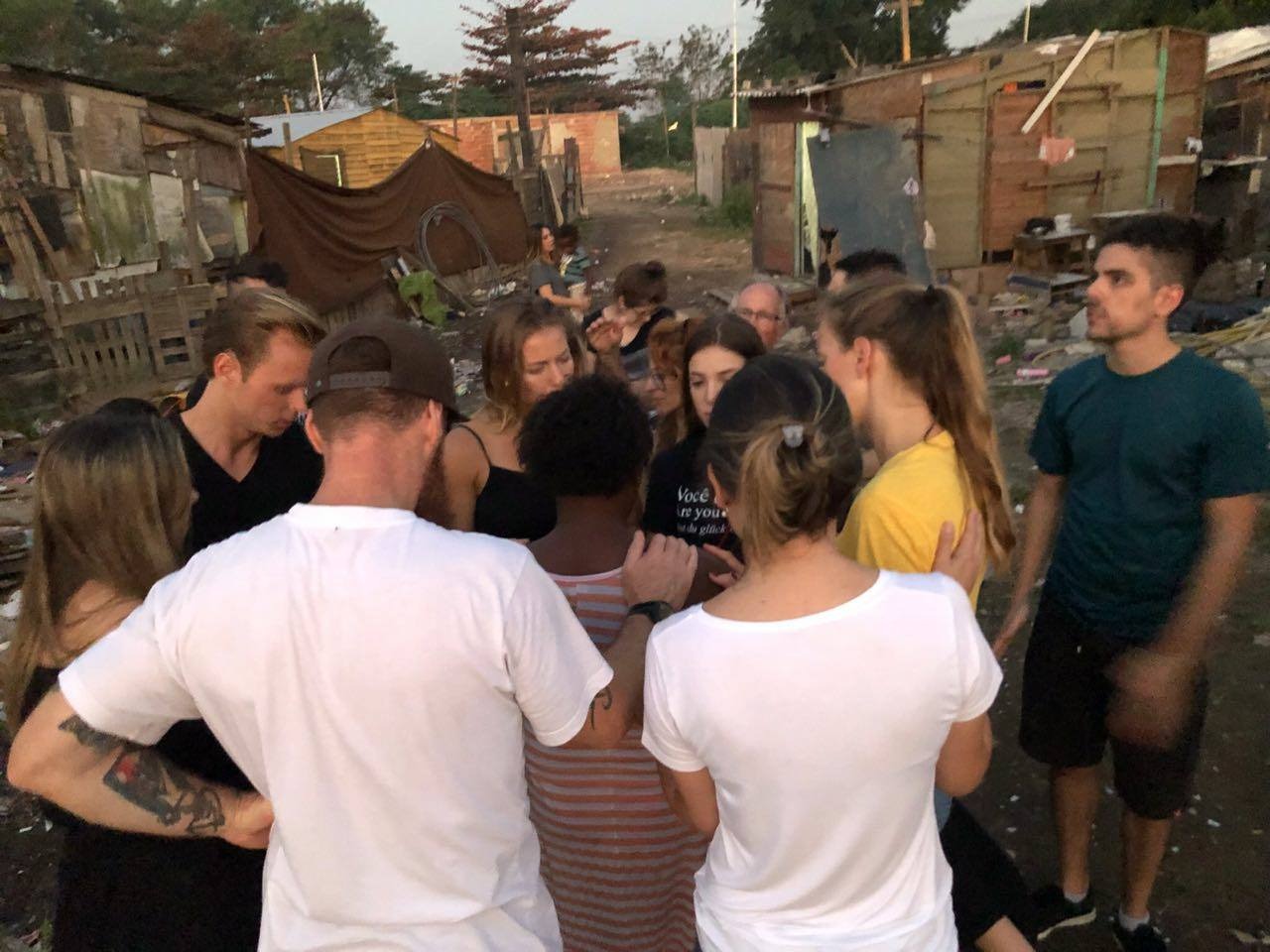 Equipe orando por moradora na comunidade